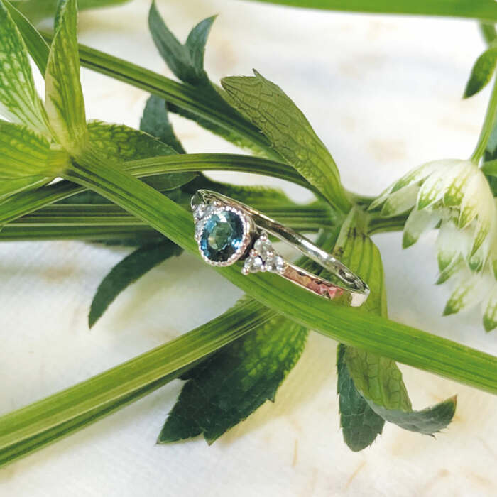 La bague Laura en or gris palladié 18 carats faimined sertie d'un saphir teal blue et de 6 saphirs verts, pièce unique taille 53